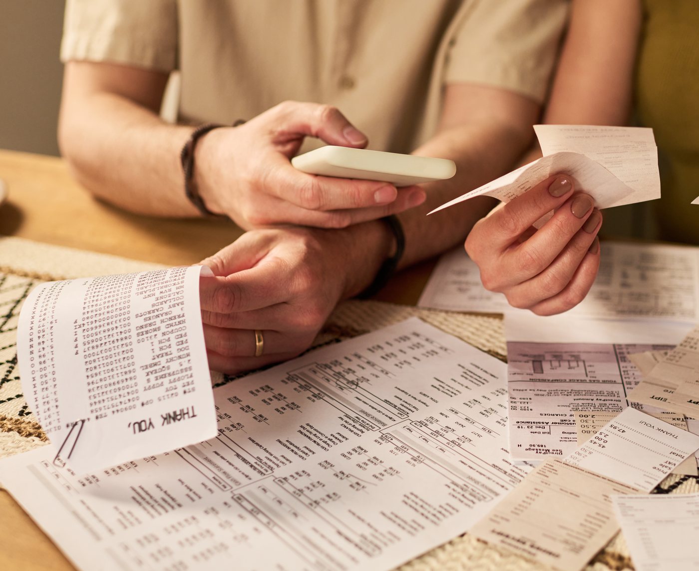 A pile of unsorted till slips and receipts on a kitchen table at tax time